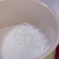 Met die hand melk opschuimen vir 'n cappuccino