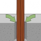 Die plaas van 'n hout heiningpaal