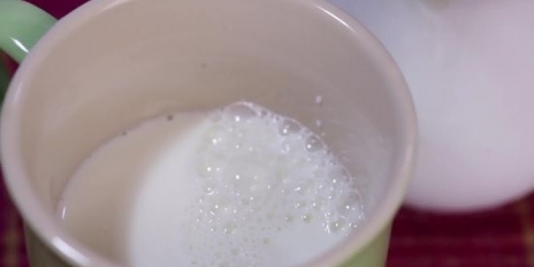 Met die hand melk opschuimen vir 'n cappuccino
